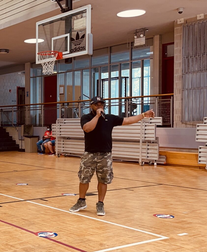 DJ Webstar with microphone in Johnson Community Center gym